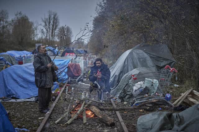 Refugees light a fire to keep warm at daybreak next to an old railway line at Dunkirk. At least 27 people, including five women and a young girl, died on Wednesday trying to cross the Channel to the UK in an inflatable dinghy in an incident in which the International Organisation for Migration described as the biggest single loss of life in the Channel since it began collecting data in 2014.  (Photo by Kiran Ridley/Getty Images)