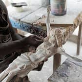 Sculptor Anthony Agasi works on a figure of Jesus Christ at his workshop in Onitsha, Nigeria, the world's most dangerous country to be a Christian (Picture: Patrick Meinhardt/AFP via Getty Images)