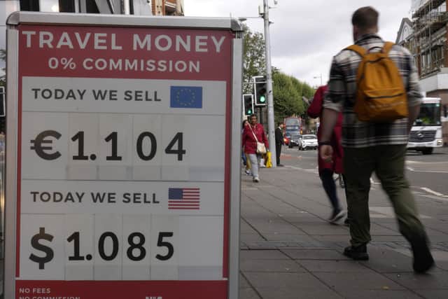 Pedestrians pass a currency exchange sign outside a shop in London. Picture: AP Photo/Kirsty Wigglesworth