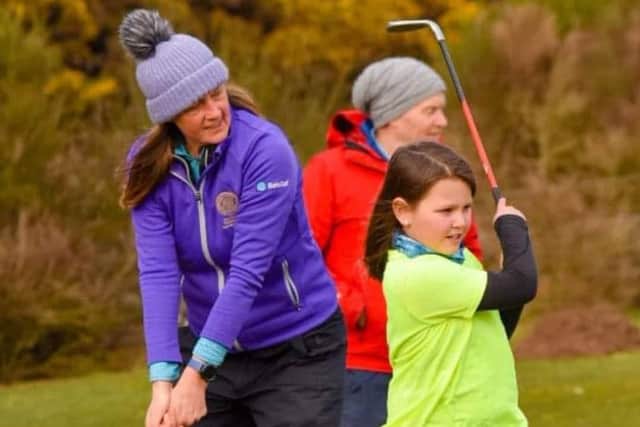 Karyn Dallas offers some swing advice to one of her young pupils