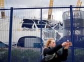 A pedestrian takes a selfie with the wind-damaged roof of The O2 Arena, in London after Storm Eunice battered the country