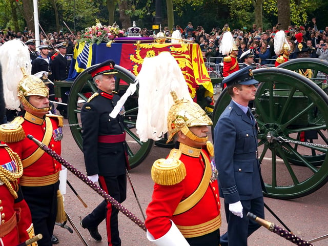 The State Gun Carriage carries the coffin of Queen Elizabeth II, draped in the Royal Standard with the Imperial State Crown and the Sovereign's orb and sceptre, in the Ceremonial Procession following her State Funeral at Westminster Abbey, London. Picture date: Monday September 19, 2022.