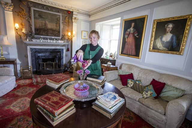 Housekeeper Lucy Whiteman dusts in the High Drawing Room.