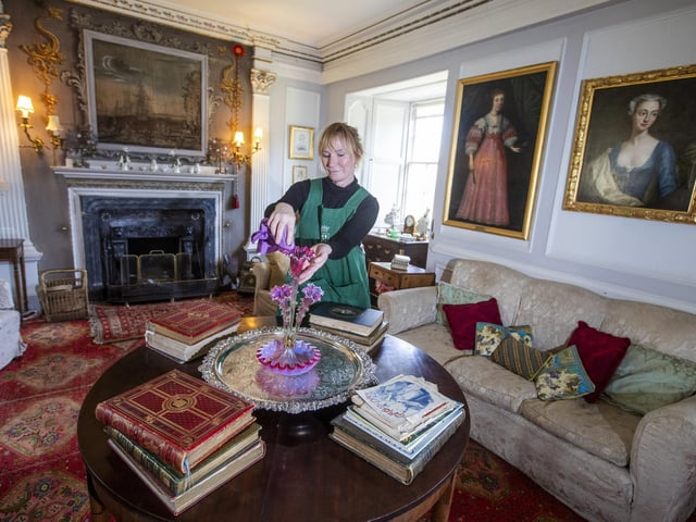 Housekeeper Lucy Whiteman dusts in the High Drawing Room.