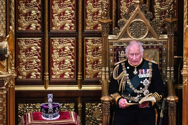 Prince Charles reads the Queen's Speech as he sits by the Imperial State Crown in the House of Lords Chamber