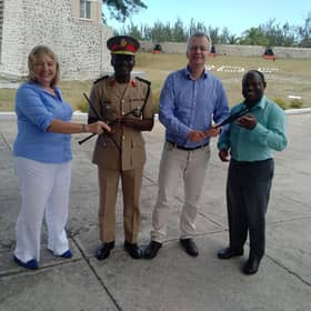 Carol Anderson (left) hands over chanters to the Barbados Defence Force Band, with hopes to set up a pipe band with young army cadets. PIC: Contributed.