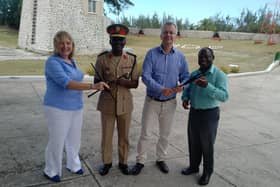 Carol Anderson (left) hands over chanters to the Barbados Defence Force Band, with hopes to set up a pipe band with young army cadets. PIC: Contributed.