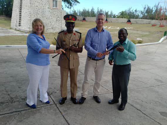 Carol Anderson (left) hands over chanters to the Barbados Defence Force Band, with hopes to set up a pipe band with young army cadets. PIC: Contributed.