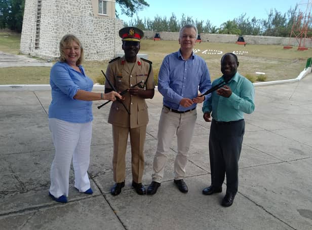 Carol Anderson (left) hands over chanters to the Barbados Defence Force Band, with hopes to set up a pipe band with young army cadets. PIC: Contributed.
