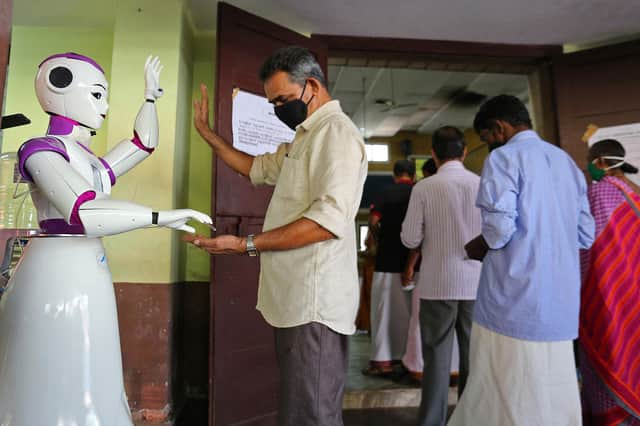 A robot dispenses sanitiser as a preventive measure against Covid-19 at a polling station during local state body elections in Kochi, Kerala, in December (Picture: AFP via Getty Images)