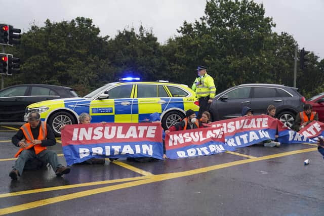 Police officers break up an Insulate Britain protest occupying a roundabout leading from the M25 motorway to Heathrow Airport (Picture: Steve Parsons/PA)