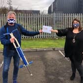 David Torrance MSP with his pogo stick handing the donation over to Lynne Scott.