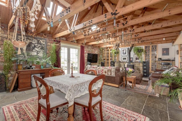At the heart of the cottage is a large open-plan living and dining area with wood-burning stove, exposed stone walls and flagstone floors