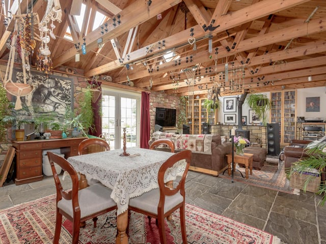 At the heart of the cottage is a large open-plan living and dining area with wood-burning stove, exposed stone walls and flagstone floors