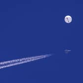 A large balloon drifts above the Atlantic Ocean, just off the coast of South Carolina, with a fighter jet and its contrail seen below it. Picture: Chad Fish via AP