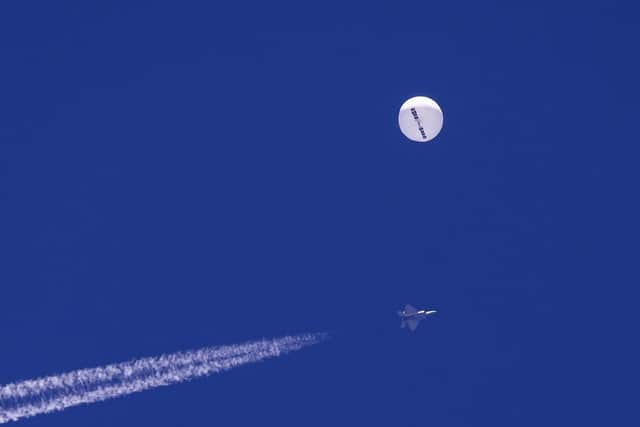 A large balloon drifts above the Atlantic Ocean, just off the coast of South Carolina, with a fighter jet and its contrail seen below it. Picture: Chad Fish via AP