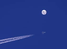 A large balloon drifts above the Atlantic Ocean, just off the coast of South Carolina, with a fighter jet and its contrail seen below it. Picture: Chad Fish via AP