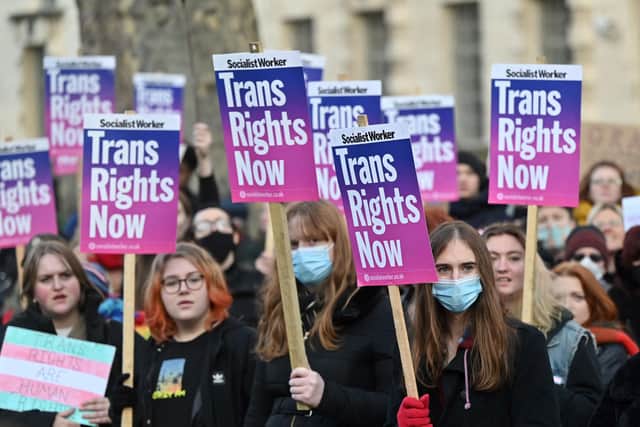 Demonstrators hold placards as they take part in a protest march in central London to show their support for Holyrood's Gender Recognition Reform Bill