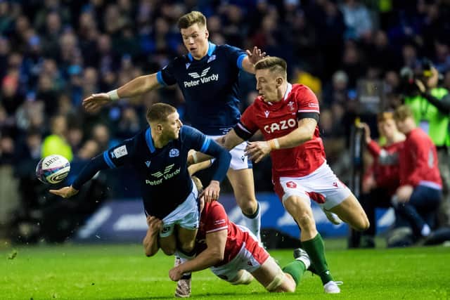 Scotland's Finn Russell offloads the ball for a Kyle Steyn try as Huw Jones watches on during the 35-7 win over Wales. (Photo by Ross Parker / SNS Group)