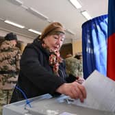 A woman casts her ballot as service members register to vote during Russia's presidential election in Moscow. (Photo by NATALIA KOLESNIKOVA / AFP)