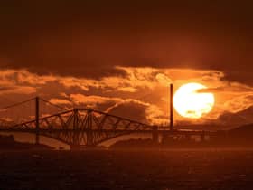 Photographer Tom Duffin, 57, captured a giant sun with clouds and the iconic bridges contrasted against it picture: SWNS