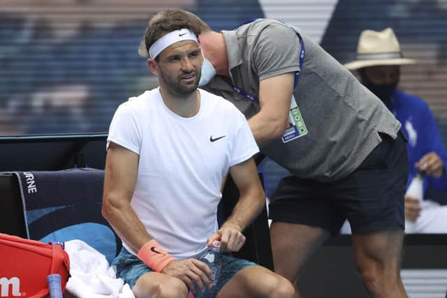 Grigor Dimitrov receives treatment during his quarter-final loss to Aslan Karatsev. Picture: Hamish Blair/AP