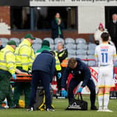 Dundee's Michael Mellon is forced off with a head injury during the match against St Johnstone.