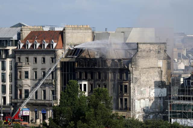 Firefighters put out the remains of a fire in the former Debenhams building on Princes Street on July 9.