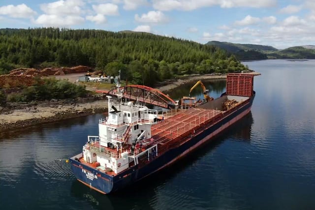 Timber being loaded and shipped by boat on Ardcastle timber pier in West Argyll.