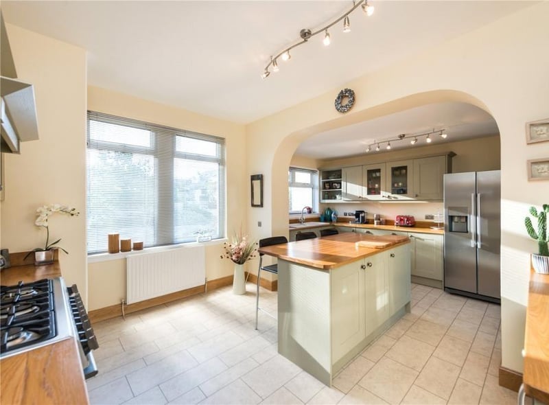 Fitted kitchen with a range of units and central island with seating, and includes a gas range cooker, double sink, boiling water tap, and separate wine fridge.
