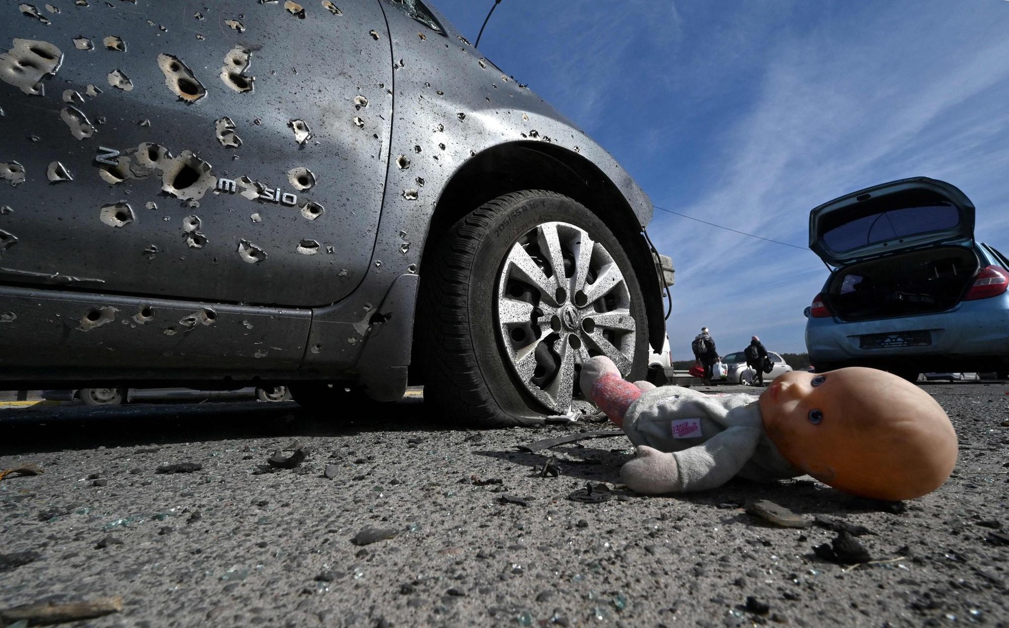 Haunting photograph shows an abandoned doll next to a car riddled with bullets north of Kyiv