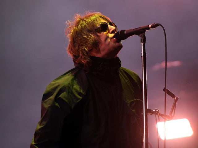 Liam Gallagher strikes a familiar pose as headlines the main stage (Photo by ANDY BUCHANAN/AFP via Getty Images)