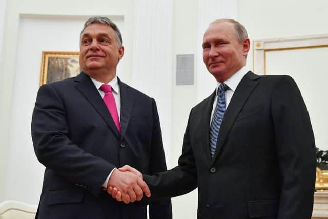 Russian President Vladimir Putin,  right, shakes hands with ally Hungary's Prime Minister Viktor Orban during a meeting at the Kremlin in Moscow
