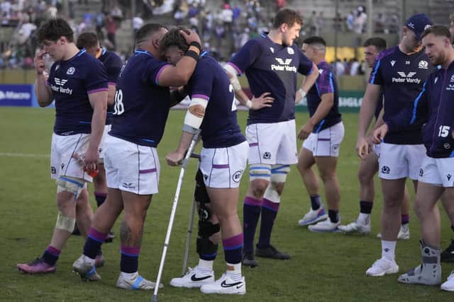 Scotland's Kyle Rowe, in crutches, is embraced by team-mate Javan Sebastian after the win over Argentina. (AP Photo/Natacha Pisarenko)