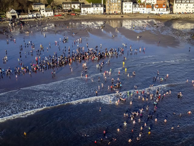 People take part in a Loony Dook New Year's Day dip in the Firth of Forth at Kinghorn in Fife.