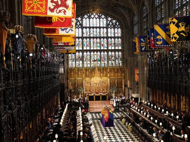 The coffin of Queen Elizabeth II, draped in the Royal Standard with the Imperial State Crown and the Sovereign's orb and sceptre, during the Committal Service at St George's Chapel in Windsor Castle