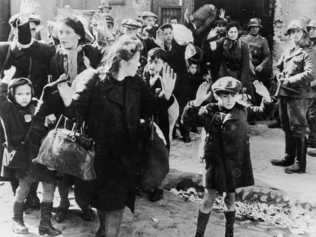 A group of Jewish civilians are held at gunpoint by German SS troops in Warsaw in 1943 (Picture: Keystone/Hulton Archive/Getty Images)