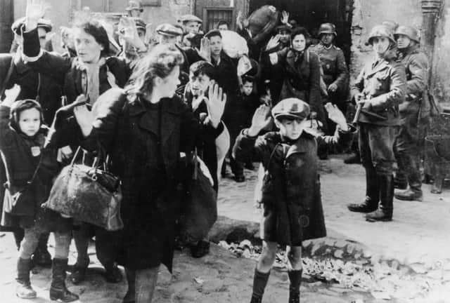 A group of Jewish civilians are held at gunpoint by German SS troops in Warsaw in 1943 (Picture: Keystone/Hulton Archive/Getty Images)