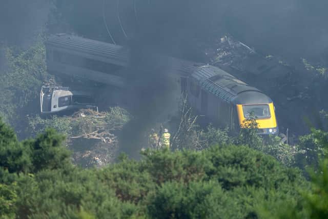 Emergency services personnel are seen at the scene of a train crash near Stonehaven in northeast Scotland. (Photo by Michal Wachucik / AFP)