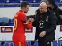 Wales' interim head coach Rob Page  shakes hands with midfielder Aaron Ramsey. (Photo by GEOFF CADDICK/AFP via Getty Images)