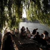 People relax by the River Seine on Ile de la Cite in Paris.