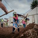 Workers from Kanyaruchinya, in Nyiragongo territory, take part in sanitation, renovation, and leveling work at the former Ebola treatment center, in Goma