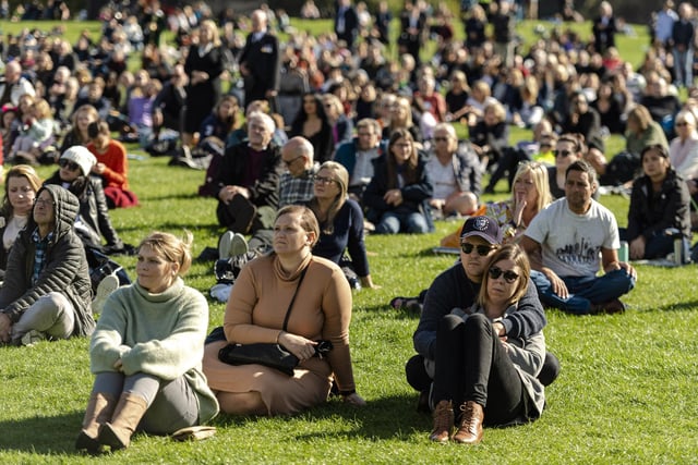 Members of the public watch Queen Elizabeth II's state funeral on a big screen in Holyrood park in Edinburgh