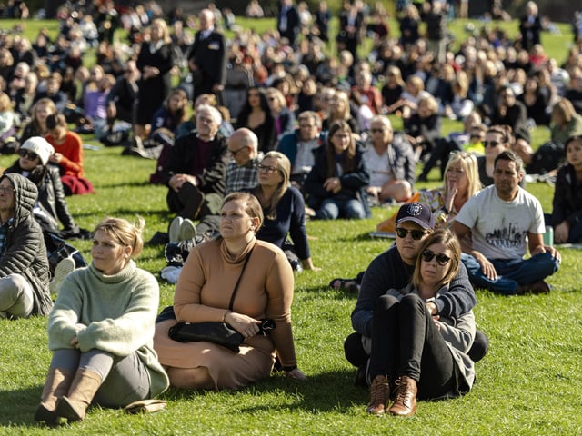 Members of the public watch Queen Elizabeth II's state funeral on a big screen in Holyrood park in Edinburgh