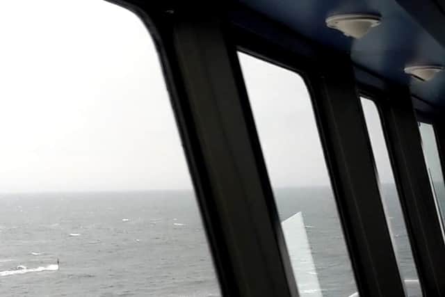 The submarine's periscope visible from the ferry.