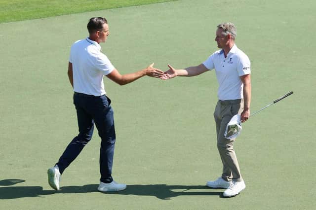Henrik Stenson and Luke Donald shake hands on the 18th green after playing together in the third round of the Hero Dubai Desert Classic at Emirates Golf Club. Picture: Andrew Redington/Getty Images.
