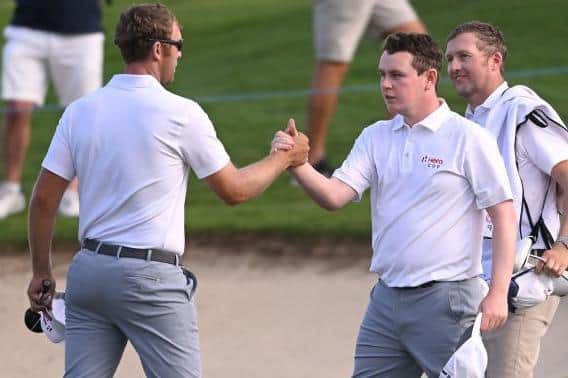 Séamus Power and Bob MacIntyre shake hands after winning their opening match together in the inaugural Hero Cup at Abu Dhabi Golf Club. Picture: Ross Kinnaird/Getty Images.