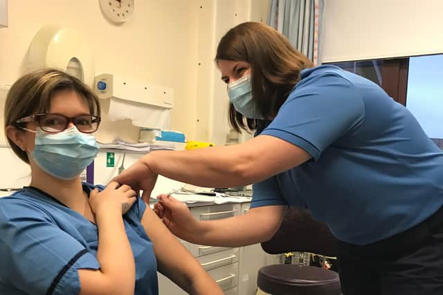 Lynsey Mackenzie receiving the vaccine from occupational health nurse Marion Campbell.