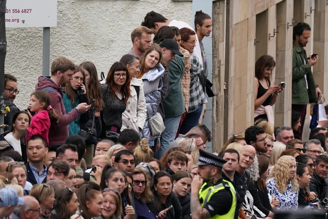 People in Cannongate, Edinburgh ahead of the passing of Queen Elizabeth II's coffin on its journey from Balmoral to Edinburgh, where it will lie at rest at the Palace of Holyroodhouse. Picture date: Sunday September 11, 2022.