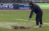 A Dundee groundsman sweeps water off the pitch at Dens Park prior to the match against Aberdeen being postponed. (Photo by Mark Scates / SNS Group)